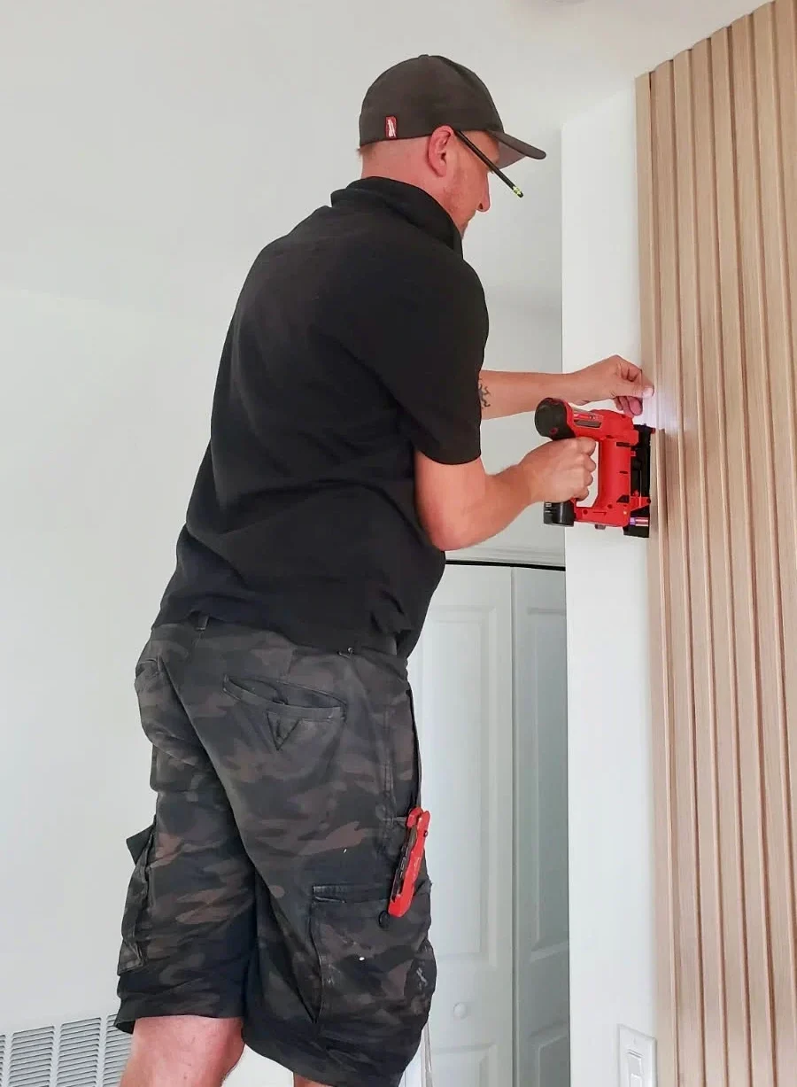 Marcin — founder of 6M Design — installing custom trim work on a Naples FL home renovation